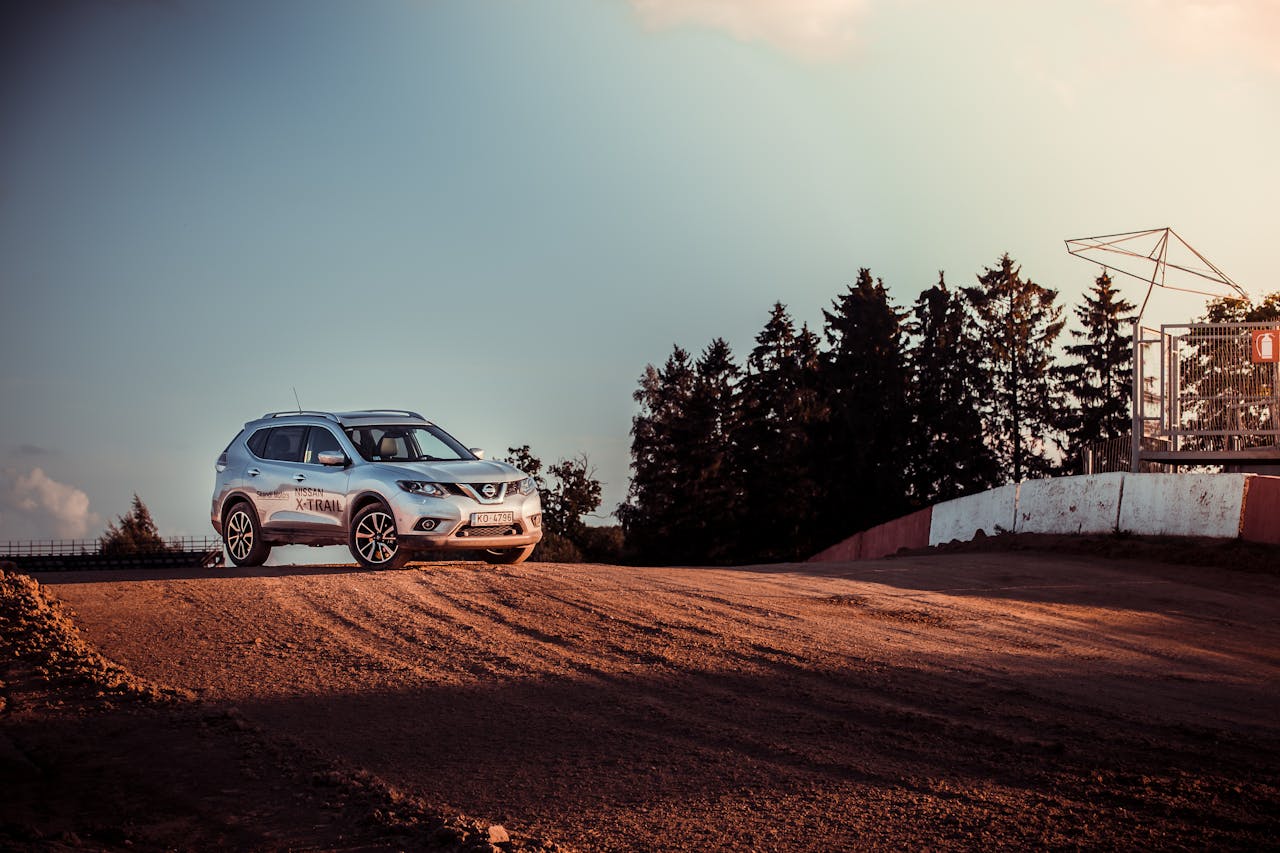 A Nissan SUV parked on a dirt road, capturing the essence of adventure and nature at sunset.