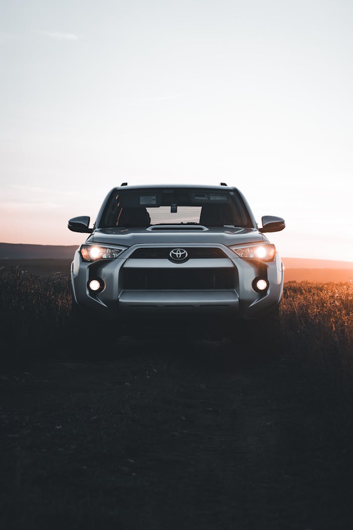 Front view of a silver Toyota 4Runner SUV parked in nature during sunset.